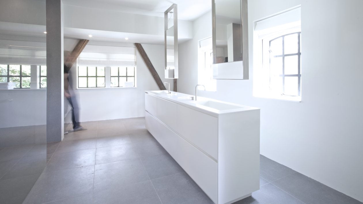 Badkamer in Warffum. Het vrijstaande meubel is ontworpen door Studiodoccia en custom made door NotOnlyWhite. De rozetten van de kranen (Vola) zijn verzonken in het Himacs blad.