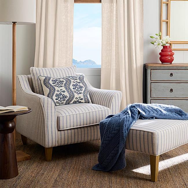 Cómoda en color baby blue envejecido (995 euros) y sillón con reposapiés con tapizado de rayas en azul bebé y crudo, todo de El Corte Inglés.